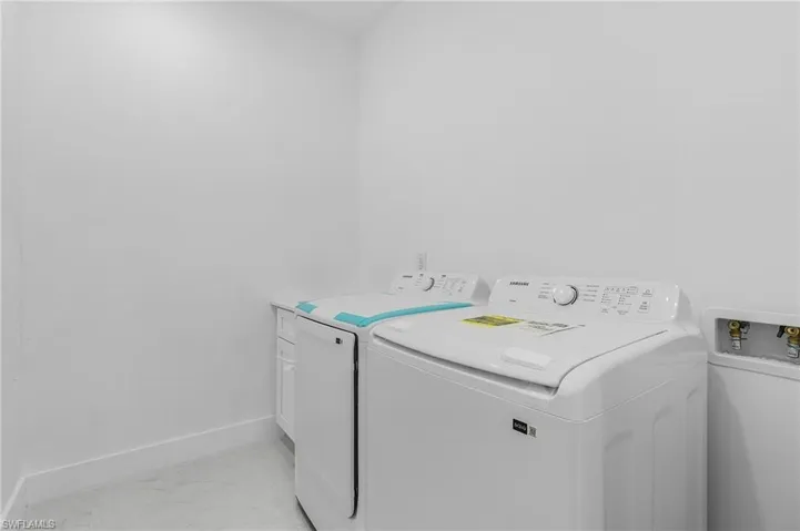 Clothes washing area with washer and clothes dryer and cabinets