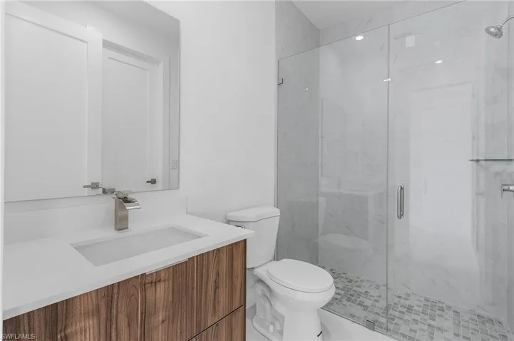Bathroom with walk in shower, vanity, and toilet
