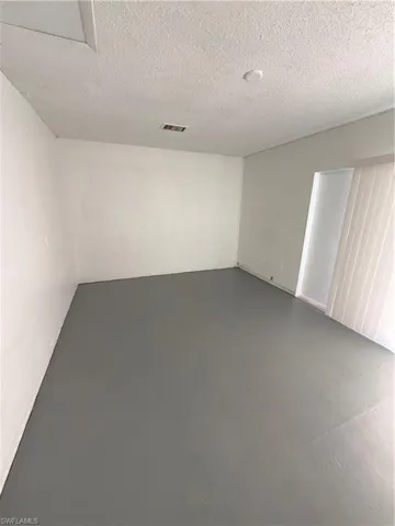 Unfurnished room with concrete floors and a textured ceiling