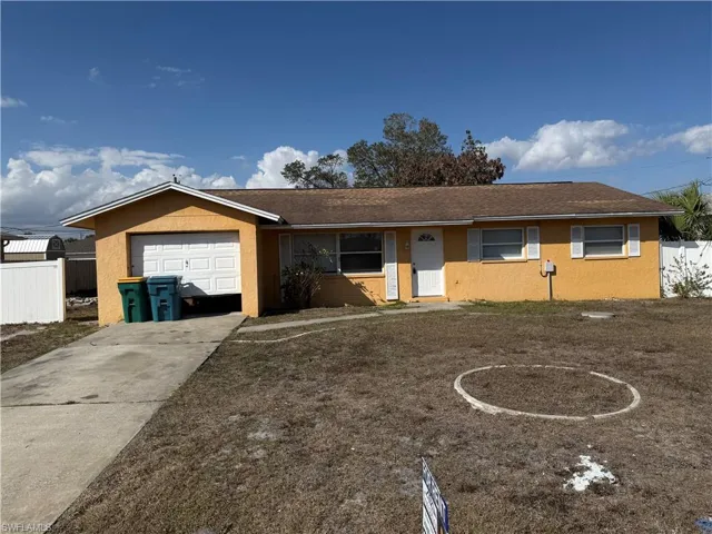 Ranch-style house featuring concrete driveway and a garage