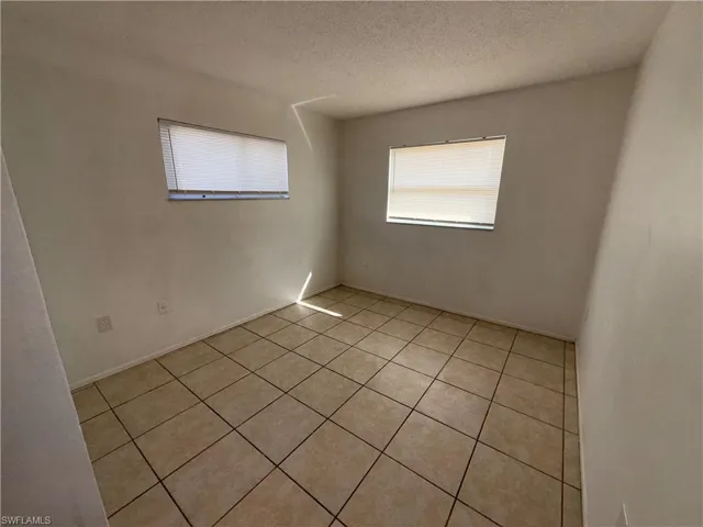 Spare room featuring a textured ceiling and light tile patterned floors