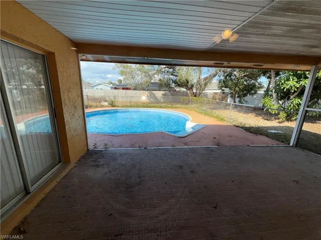View of swimming pool with patio surround and a fenced backyard