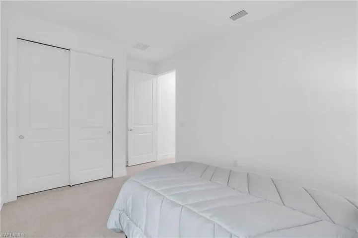 Carpeted bedroom with a closet