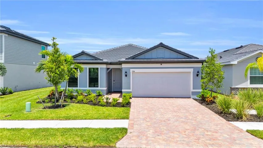 View of front of property featuring a garage and a front lawn