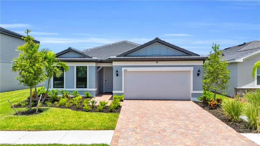 View of front of home with a garage and a front lawn