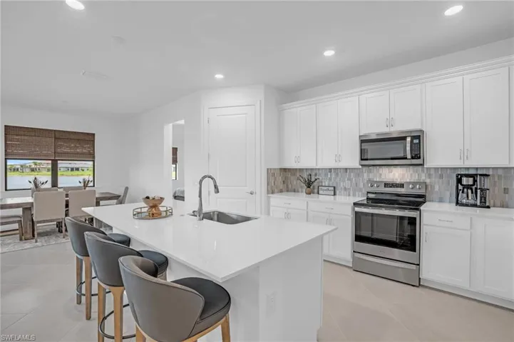 Kitchen featuring white cabinetry, light tile patterned floors, appliances with stainless steel finishes, and sink