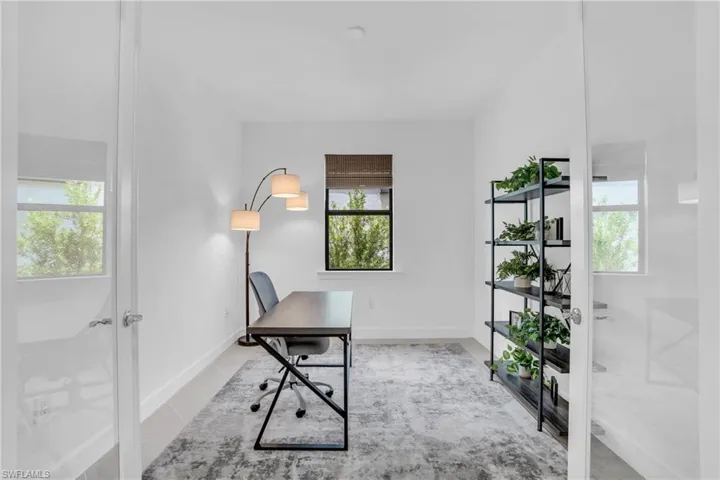 Home office with light tile patterned flooring and french doors