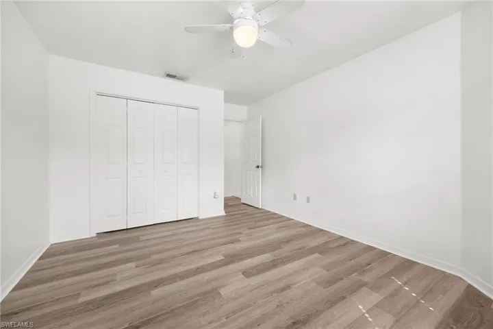 Recessed lighting, wood-finish flooring, ceiling fan, bi-fold closet doors, white paneled interior door