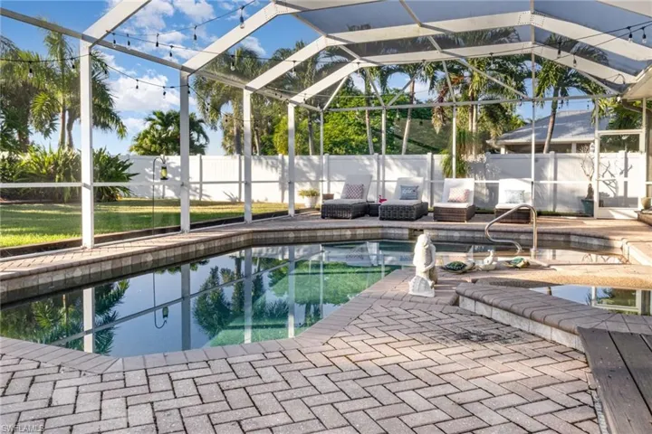 View of swimming pool with a fenced backyard, glass enclosure, a sunroom, and a patio area