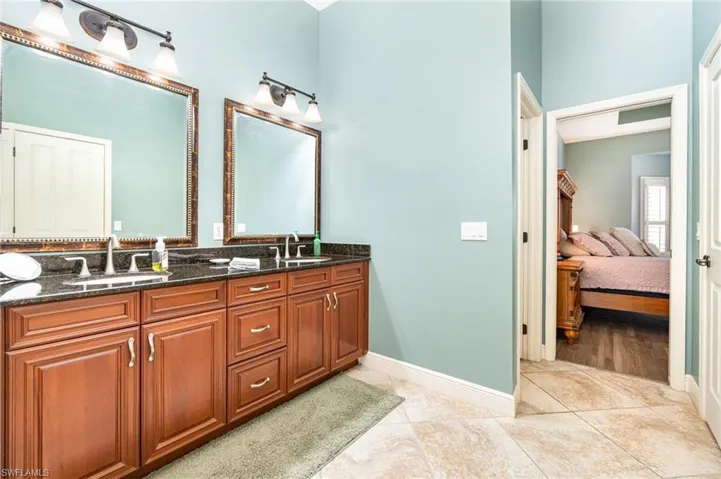 Ensuite bathroom with double vanity and light tile patterned floors