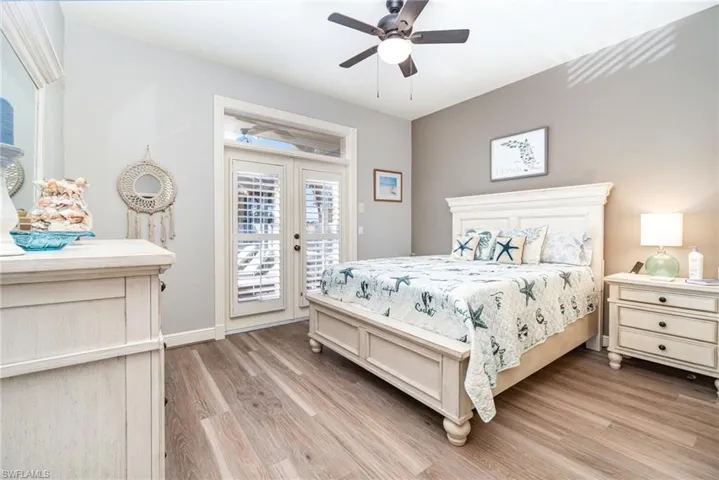 Bedroom with light wood finished floors, access to outside, and a ceiling fan