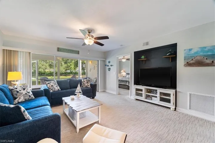 Living area with a ceiling fan and light carpet