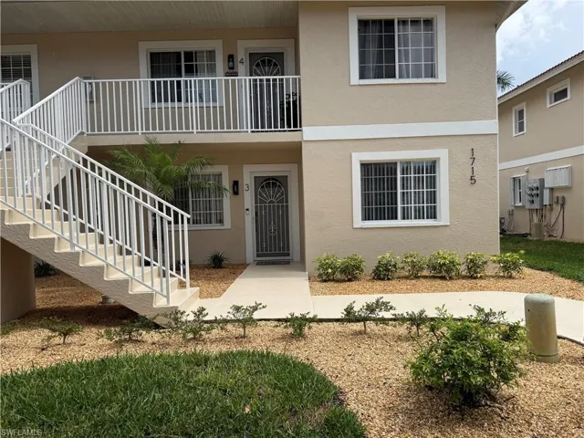 Exterior apartment building featuring a neutral-toned stucco finish