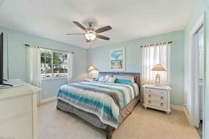 Bedroom with light carpet and a ceiling fan