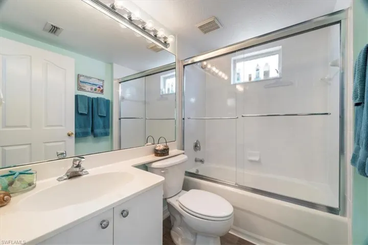 Full bathroom featuring vanity and bath / shower combo with glass door