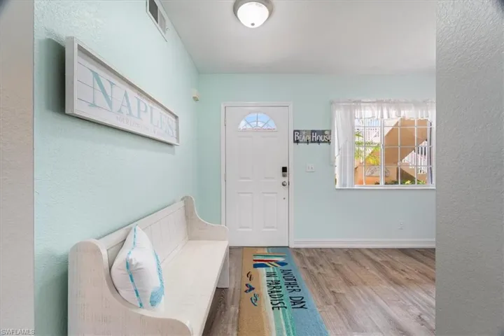 Entryway with wood finished floors and a textured wall