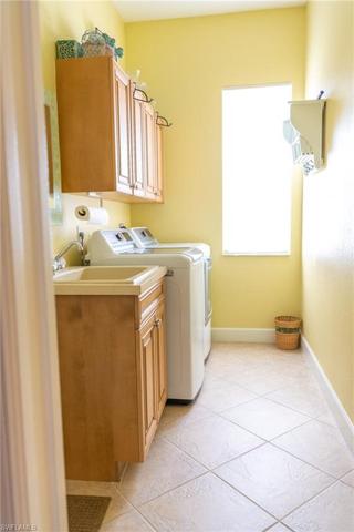 Laundry room with full size washer and dryer, cabinets for storage, sink and window for lots of natural light.