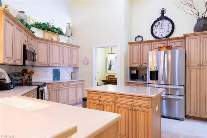 Kitchen has an island with storage and stainless steel appliances.