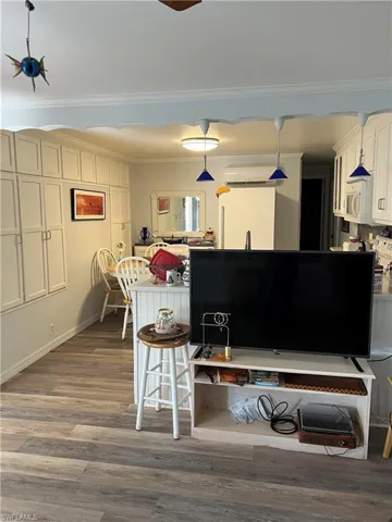 Kitchen featuring ornamental molding, hardwood / wood-style floors, and pendant lighting