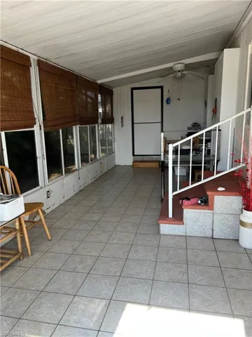 Unfurnished sunroom featuring ceiling fan