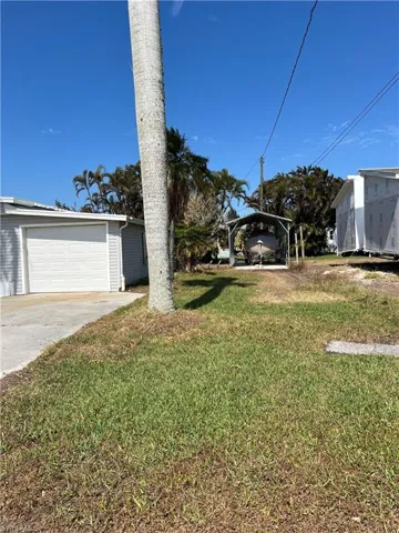 View of front of home with a carport and a front lawn