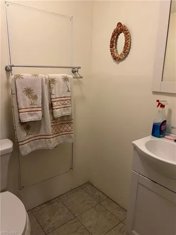 Bathroom with vanity, toilet, and tile patterned flooring