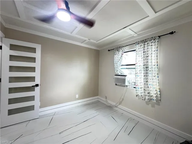 Spare room with marble look tile flooring and cooling unit
