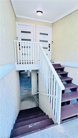 Stairs featuring a textured wall