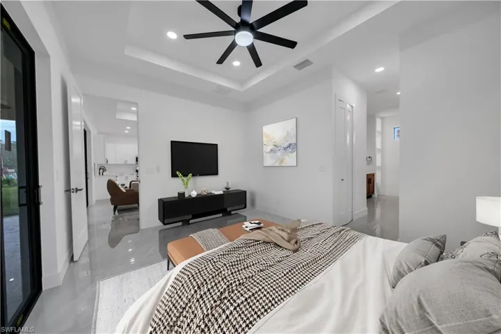 Bedroom featuring recessed lighting, a raised ceiling, and ceiling fan