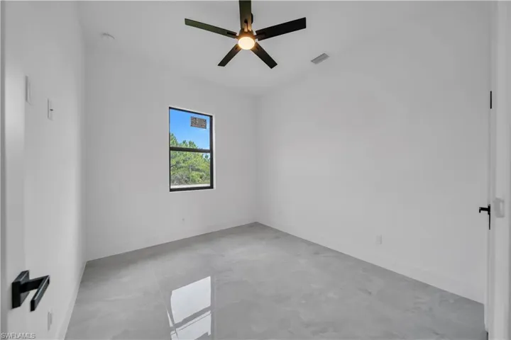 Empty room featuring a ceiling fan and baseboards