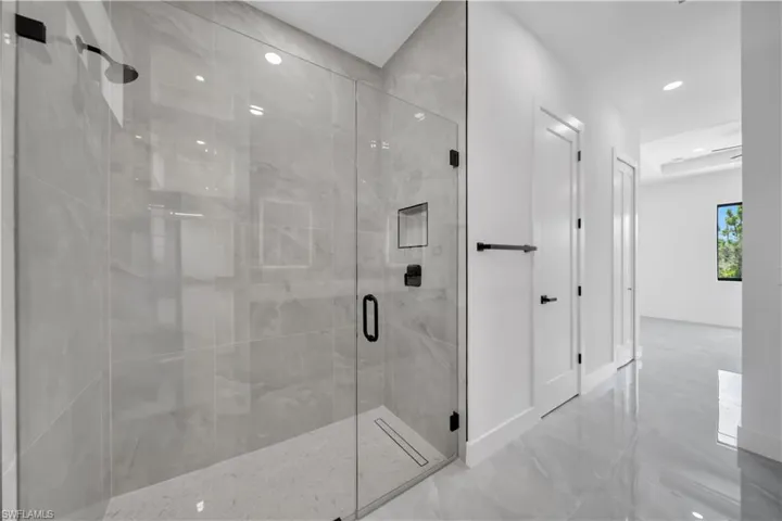 Full bath featuring a stall shower, recessed lighting, and marble finish floors