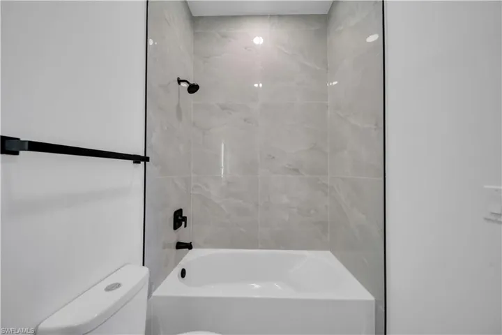 Bathroom featuring toilet and bathing tub / shower combination