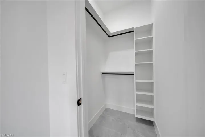 Spacious closet with light marble finish floors