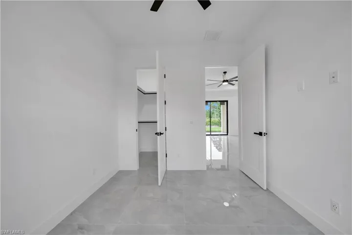 Spare room featuring ceiling fan and light marble finish flooring