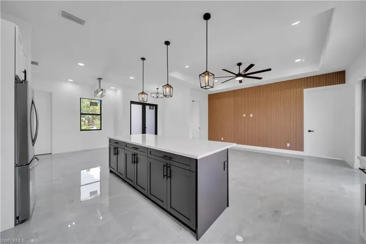 Kitchen featuring freestanding refrigerator, light marble finish floors, ceiling fan, open floor plan, and recessed lighting