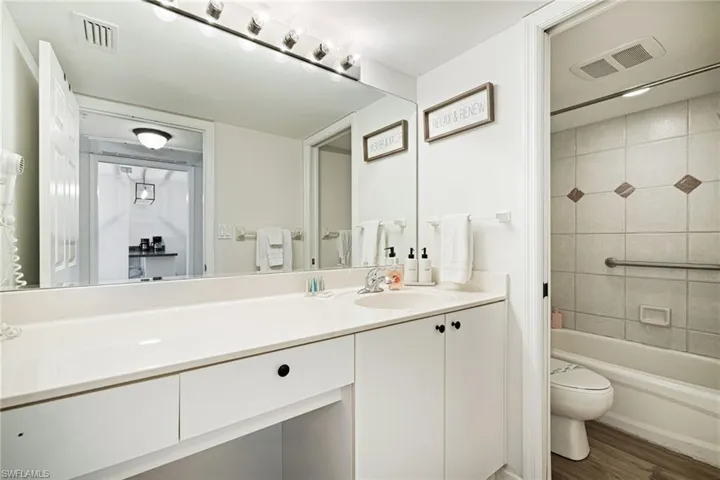 Full bath featuring vanity, wood finished floors, and  shower combination