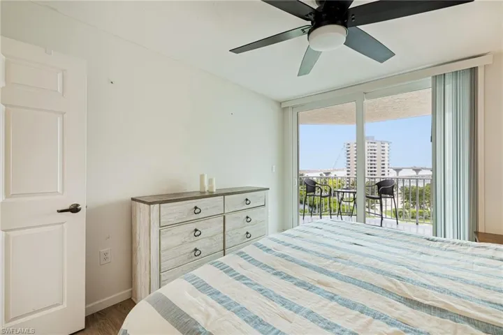 Bedroom with access to exterior, wood finished floors, and ceiling fan