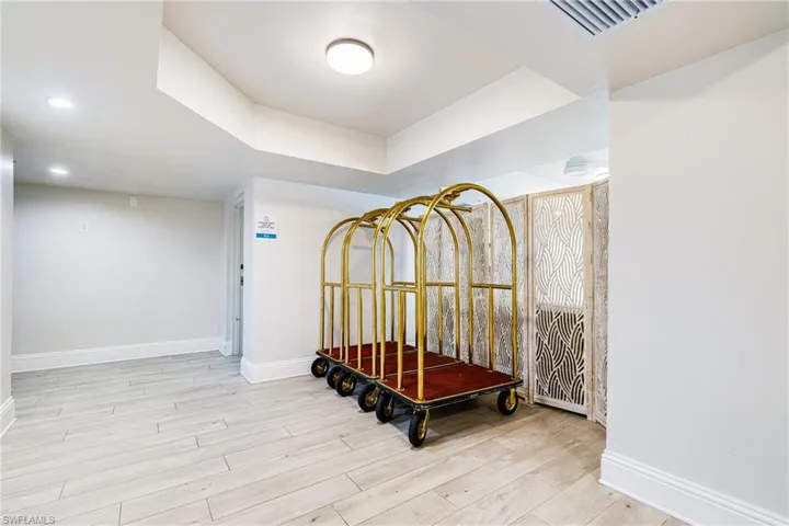 Hall featuring wood finished floors and a tray ceiling