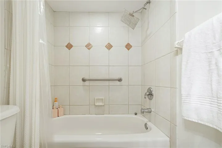Full bath with shower / bath combination with curtain and toilet