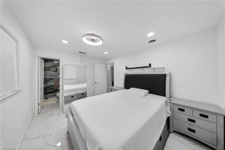 Bedroom featuring white walls and marble-look tile flooring