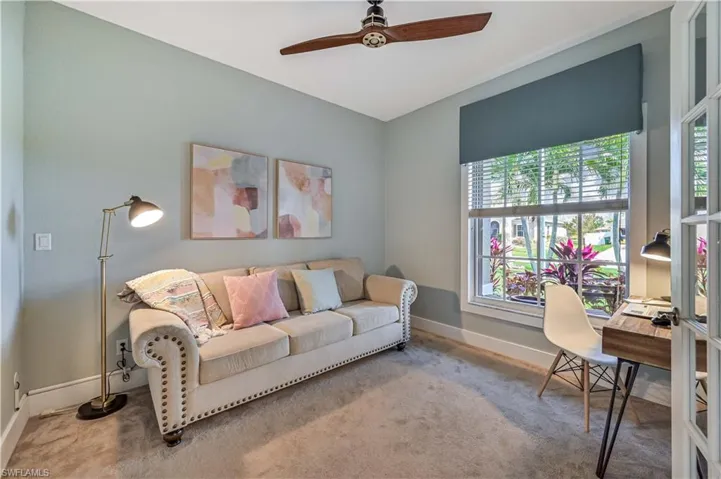 Den with carpet flooring, baseboards, and ceiling fan