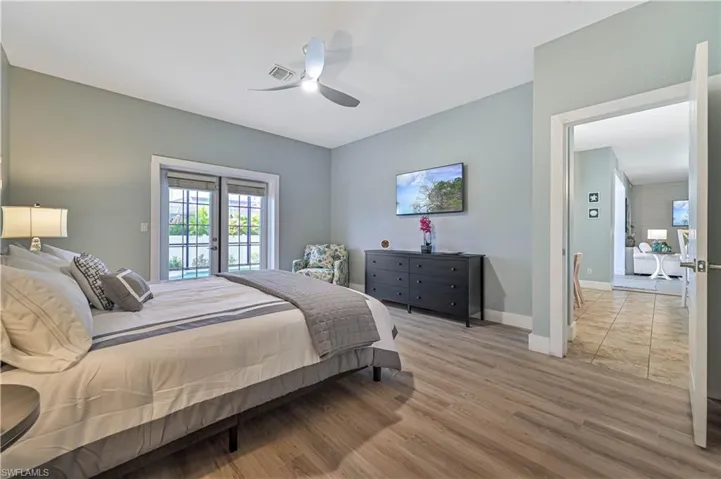 Bedroom featuring light wood-type flooring, visible vents, french doors, baseboards, and access to exterior