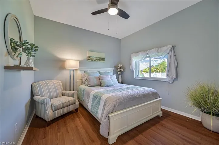Bedroom with a ceiling fan, wood finished floors, and baseboards