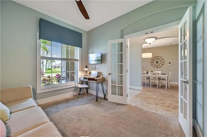 Carpeted office with lofted ceiling, french doors, and baseboards