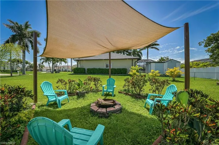 View of yard featuring fence and an outdoor fire pit