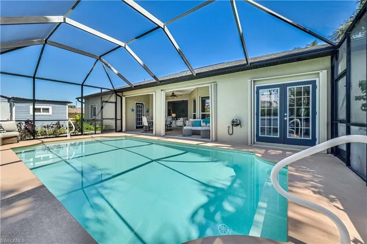 Pool with glass enclosure, a patio, ceiling fan, and outdoor lounge area