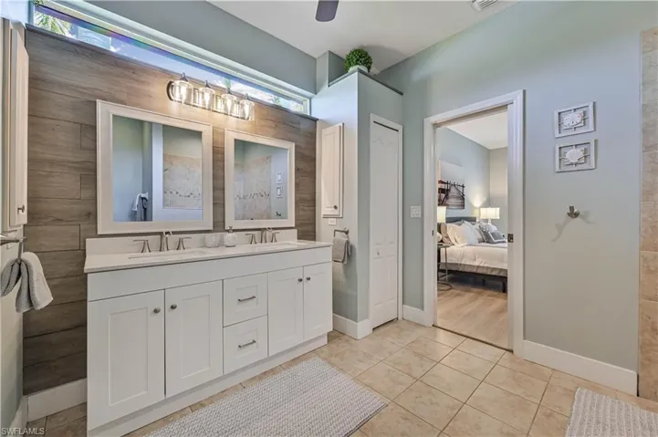 Ensuite bathroom with a sink, ensuite bathroom, double vanity, and tile patterned floors