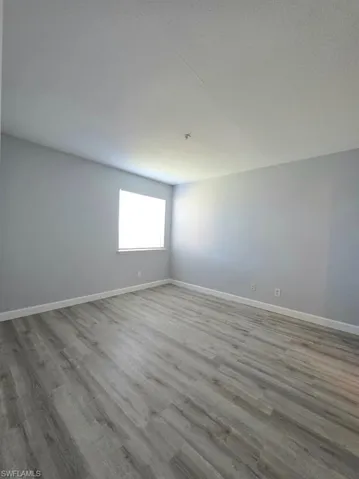 Unfurnished room featuring light wood-type flooring, a textured ceiling, a ceiling fan, and ornamental molding