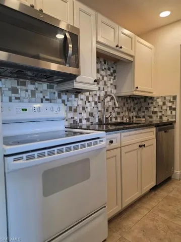 Laundry room with cabinet space, a textured ceiling, and light wood-style flooring