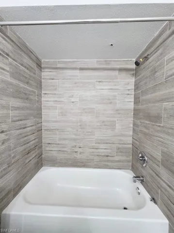 Full bathroom with vanity, dark wood-style flooring, a shower with curtain, and a textured ceiling